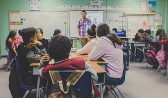 Teacher discussing fundraising event to elementary school students