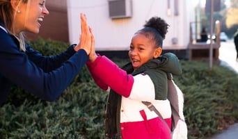 Student gives a double hi five to a Boosterthon team member.