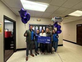 Image of school staff celebrating their $2,000 grant from Booster