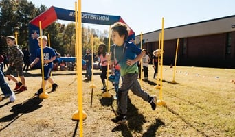 Kids running outside in an obstacle course