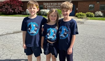 Image of students outside in from of school wearing customized school gear