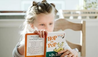 Girl reading a book at a table