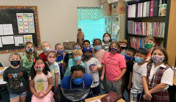 Booster team member surrounded by students