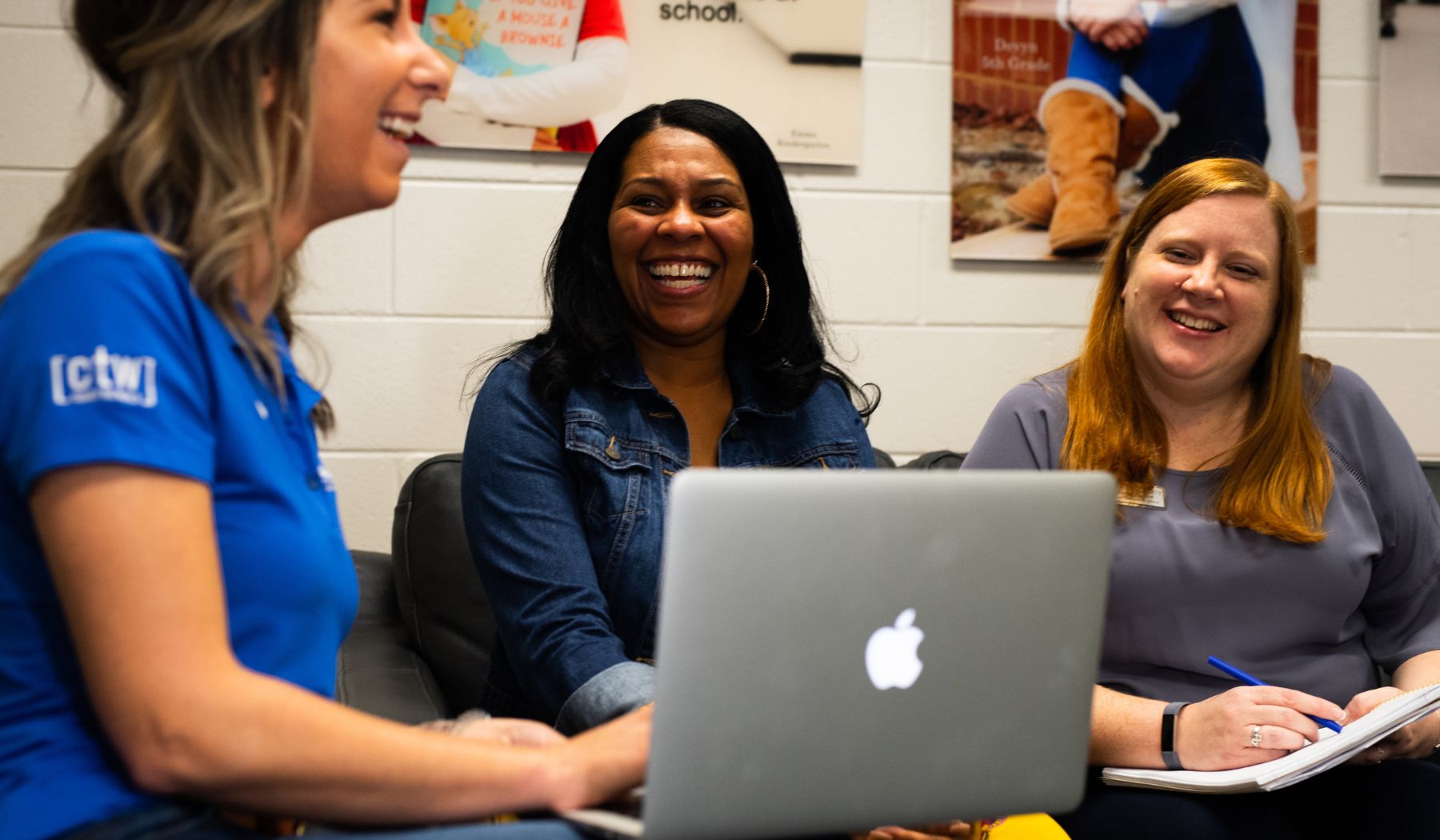 Women sitting and smiling with a computer