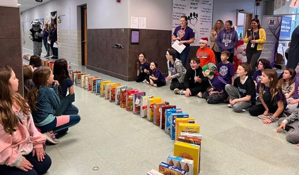 Students looking at domino-like line of cereal boxes. 