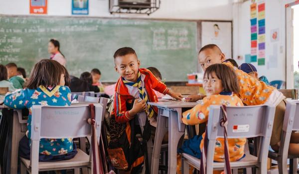 child dressed in fun clothes sitting in classroom