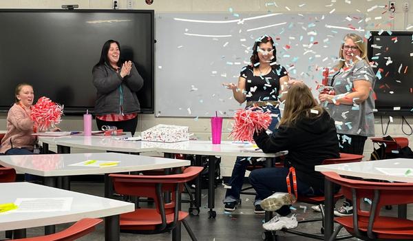 Staff celebrating November's Volly Award winner Megan in a classroom