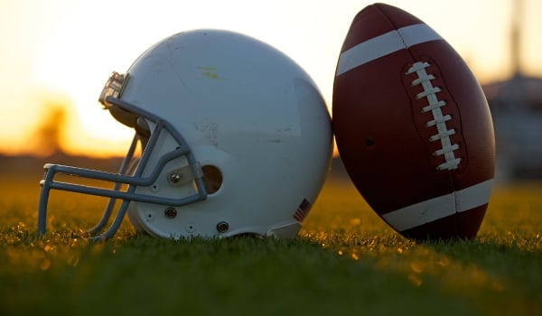 image of football and football helmet on a high school football field