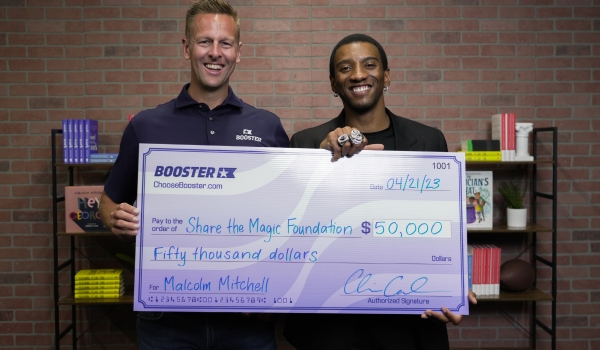 Images of CEO and Founder Chris Carneal and Malcolm Mitchell holding a $50,000 donation check together