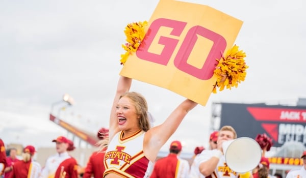 Highschool Cheerleader holding up a GO sign cheering on the team