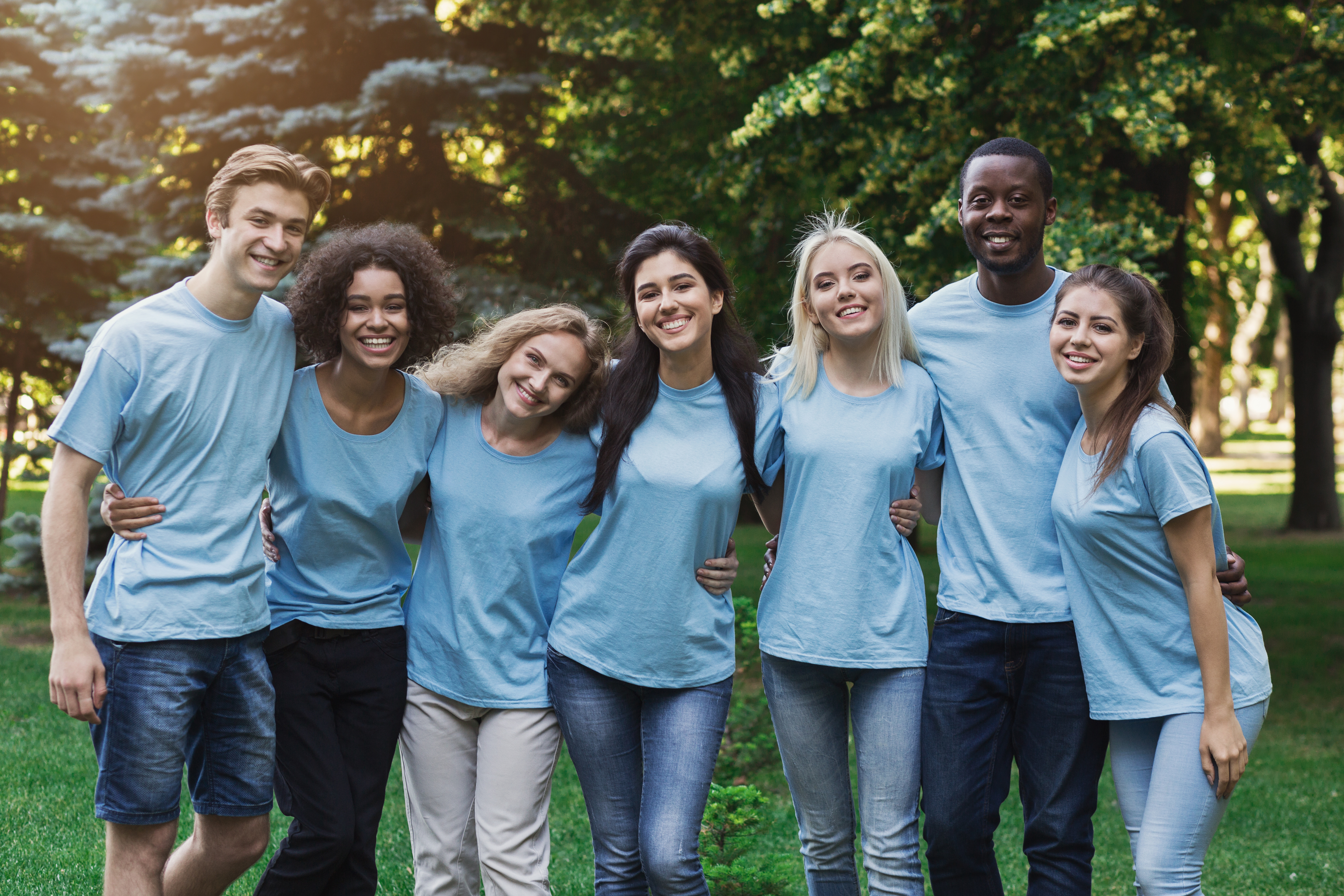 Adults in the same blue shirt hugging outside