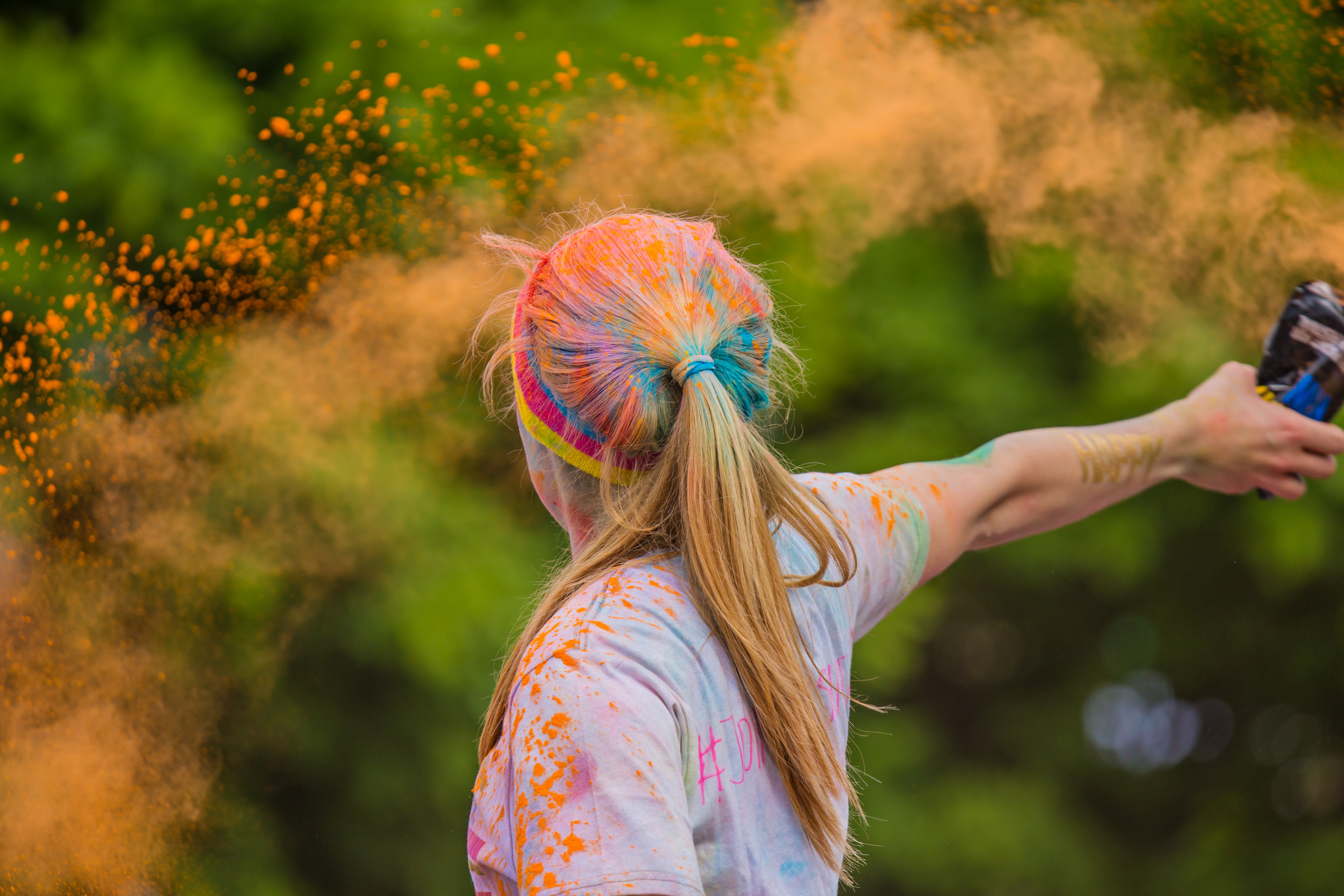 girl with color chalk on her hair and throwing it out